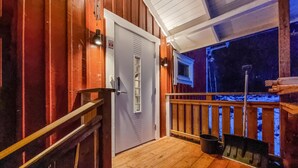 A wooden deck with a metal railing, a door with a window, and a snow-covered ground. - Awesome home in Skepplanda (Skepplanda)