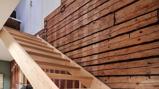 A wooden staircase leading to a room with a sloped ceiling and a wooden wall. - Awesome home in Skepplanda (Skepplanda)