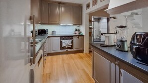 A modern kitchen with stainless steel appliances, wooden cabinets, and a tiled backsplash. - Awesome home in Skepplanda (Skepplanda)