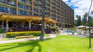 A hotel with a covered outdoor area, a swimming pool, and lush landscaping. - Stunning retreat with oceanfront views (Kihei)