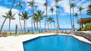 A swimming pool with a view of the ocean and palm trees. - Stunning retreat with oceanfront views (Kihei)
