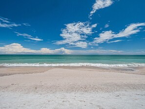 A beach with clear turquoise water and a sandy shore.