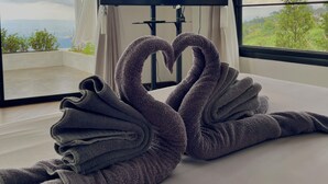 A modern room with a large window, a flat-screen TV displaying the Netflix logo, and a heart-shaped towel arrangement on the floor. - Above the clouds - Chiang rai (Chiang Rai)