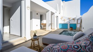 A modern, white-roofed building with a pool, a lounge area, and a staircase leading to an upper level. - Hypnōs boutique villa with amazing heated pool hot tub (Santorini)