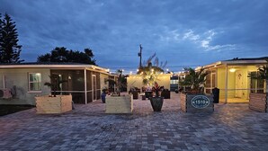 A hotel with a paved entrance, outdoor seating area, and a sign indicating 'Starfish Stays Cape Coral'.