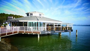 Un restaurant-bar situé au bord de l’eau, doté d’une terrasse couverte et de places assises en plein air.