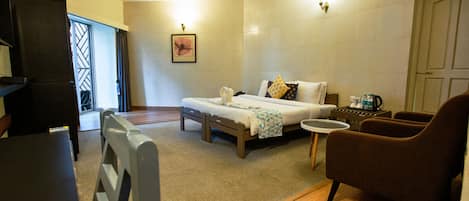 A hotel room with a bed, a small table, a chair, and a desk.