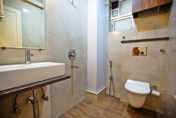 Un baño con lavamanos, inodoro y ducha.