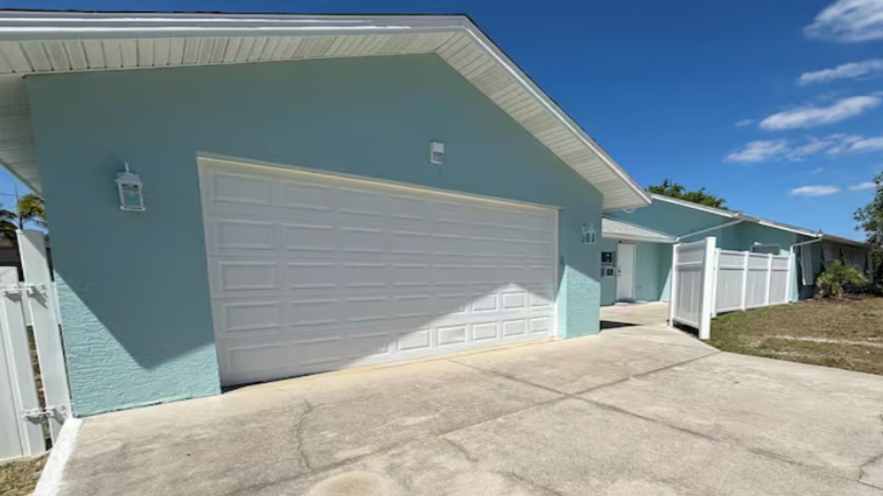 Ein Wohnhaus mit Garage, Vorgarten und blauem Himmel.