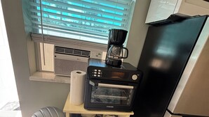 Una cocina compacta equipada con cafetera, tostadora y refrigerador.