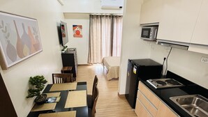 A compact kitchen with a dining area, a microwave, and a sink. - Megaworld Iloilo Condo Unit (Quezon City)