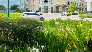 A multi-story hotel with balconies, a central entrance, and a parking area. - Megaworld Iloilo Condo Unit (Quezon City)