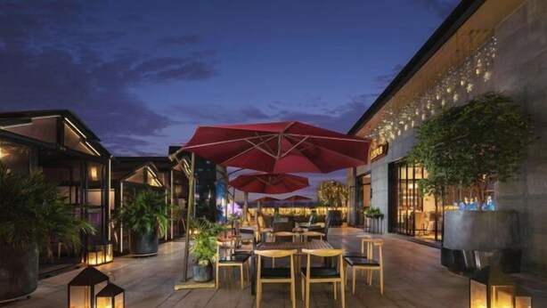 An outdoor seating area with tables and chairs, red umbrellas, and lanterns. - Nanning Datang Congyue Hotel (Wuxiang New Area Sports Center) (Nanning)