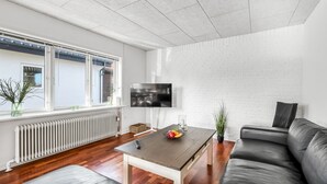A modern living room with a sofa, a coffee table, and a TV. - "Ullakarin" - 200m from the sea by Interhome (Thyborøn)