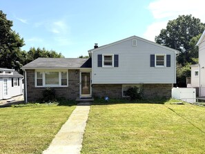 A two-story house with a front porch, a visible number '23' on the door, and a small front yard with a pathway leading to the entrance.