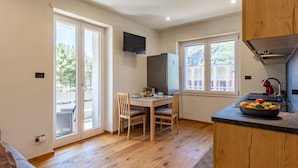 Una cocina moderna con comedor, suelo de madera y ventanas amplias.