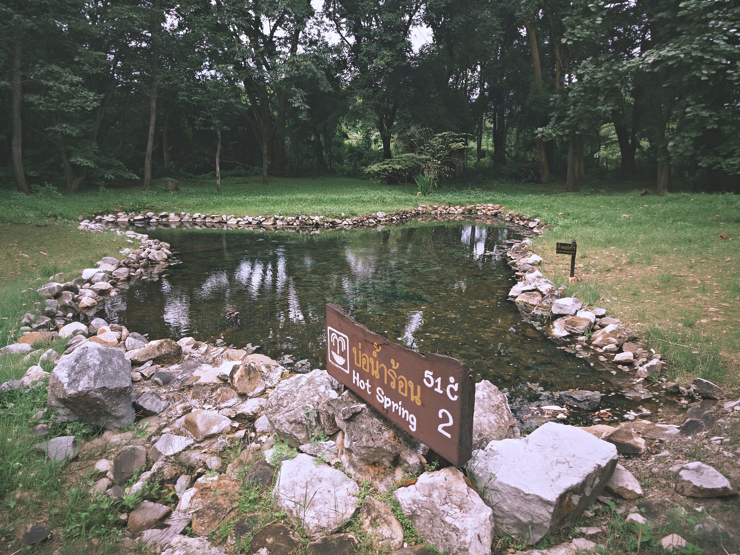 A pond with a sign indicating 'Hot Spring 2'.