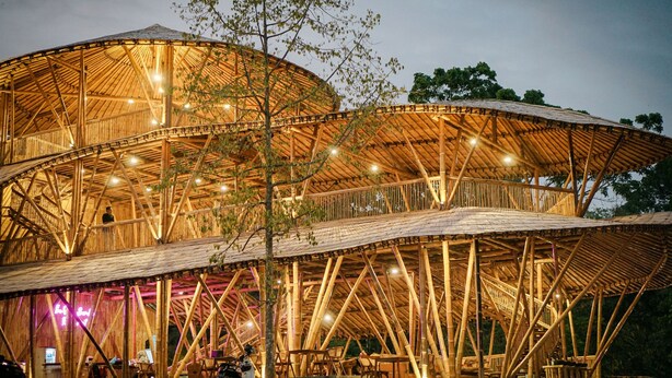 A large, open-air structure with a wooden framework and multiple levels. - The Osing Bamboo Resort - Banyuwangi (Banyuwangi)