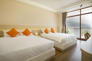 A hotel room with two beds, a balcony with a view of the mountains, and a dining area. - Sonder Quy Nhon (Quy Nhon Nam)