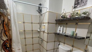 A bathroom with a shower, toilet, sink, and decorative shelves. - Amourette's Studio at Mesaavirre Garden (Bacolod)
