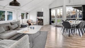 A spacious living area with a sofa, coffee table, and dining table. - "Bjart" - 1.5km from the sea by Interhome (Væggerløse)