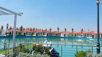 A swimming pool with a row of red-roofed buildings in the background.