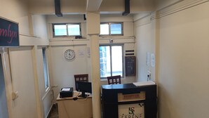 A reception desk labeled "Serene Hotel" with a clock and a window in the background. - Hotel Serene (Shillong)