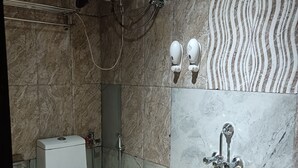 A bathroom with a toilet, a shower, and a sink. - Hotel Serene (Shillong)