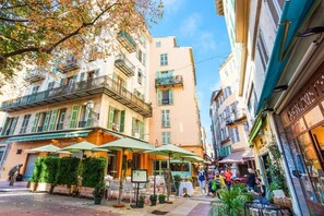 Een straat met terrasjes en een café genaamd "La Paolière".