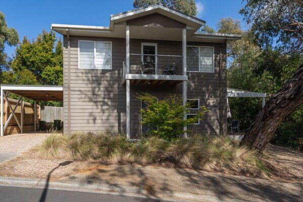 A two-story house with a covered porch and a small garden area. - Casey (Anglesea)