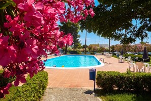 A swimming pool with surrounding lounge chairs and a clear blue sky. - Villetta Relax with pool in residence (Melendugno)