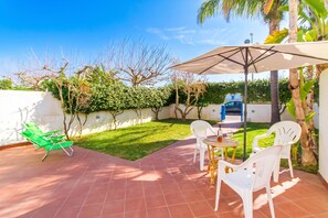 A patio with a table and chairs, a green lounge chair, and an umbrella. - Villetta Relax with pool in residence (Melendugno)