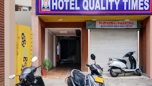 A hotel named "Hotel Quality Times" with a closed parking garage sign and two scooters parked in front. - Hotel Quality Time  (Udaipur)