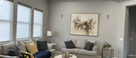 A modern living room with two sofas, a coffee table, and a ceiling fan.
