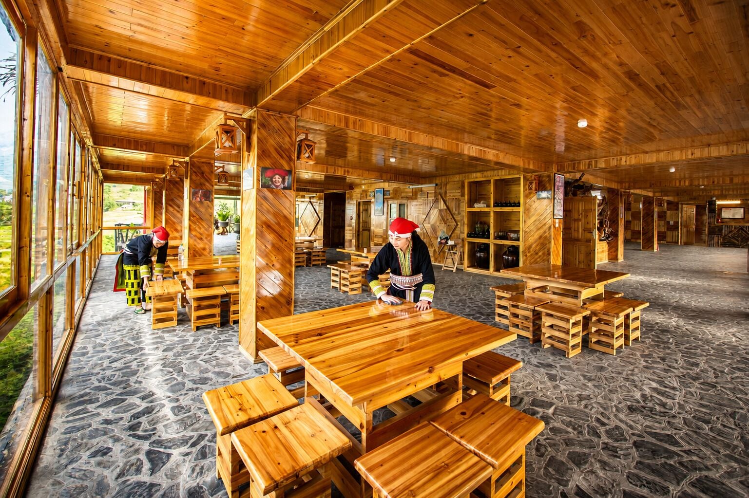 Un interior espacioso de madera con techos altos y ventanas grandes.