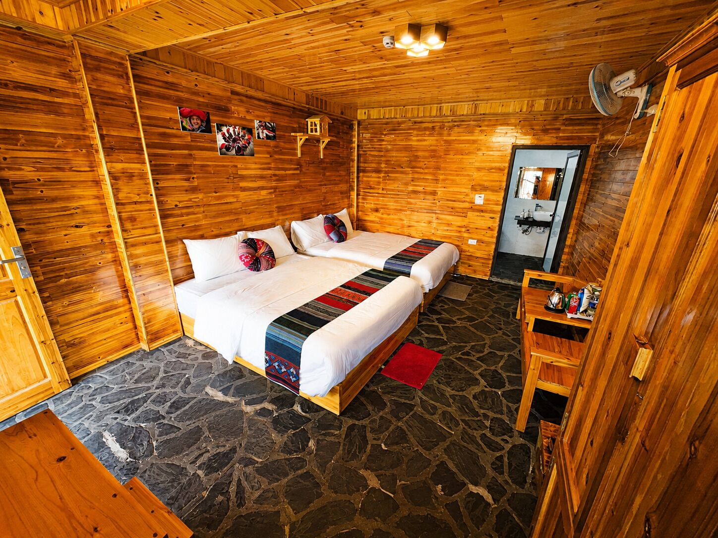 Een kamer met houten vloer, een bed en een klein tafeltje.
