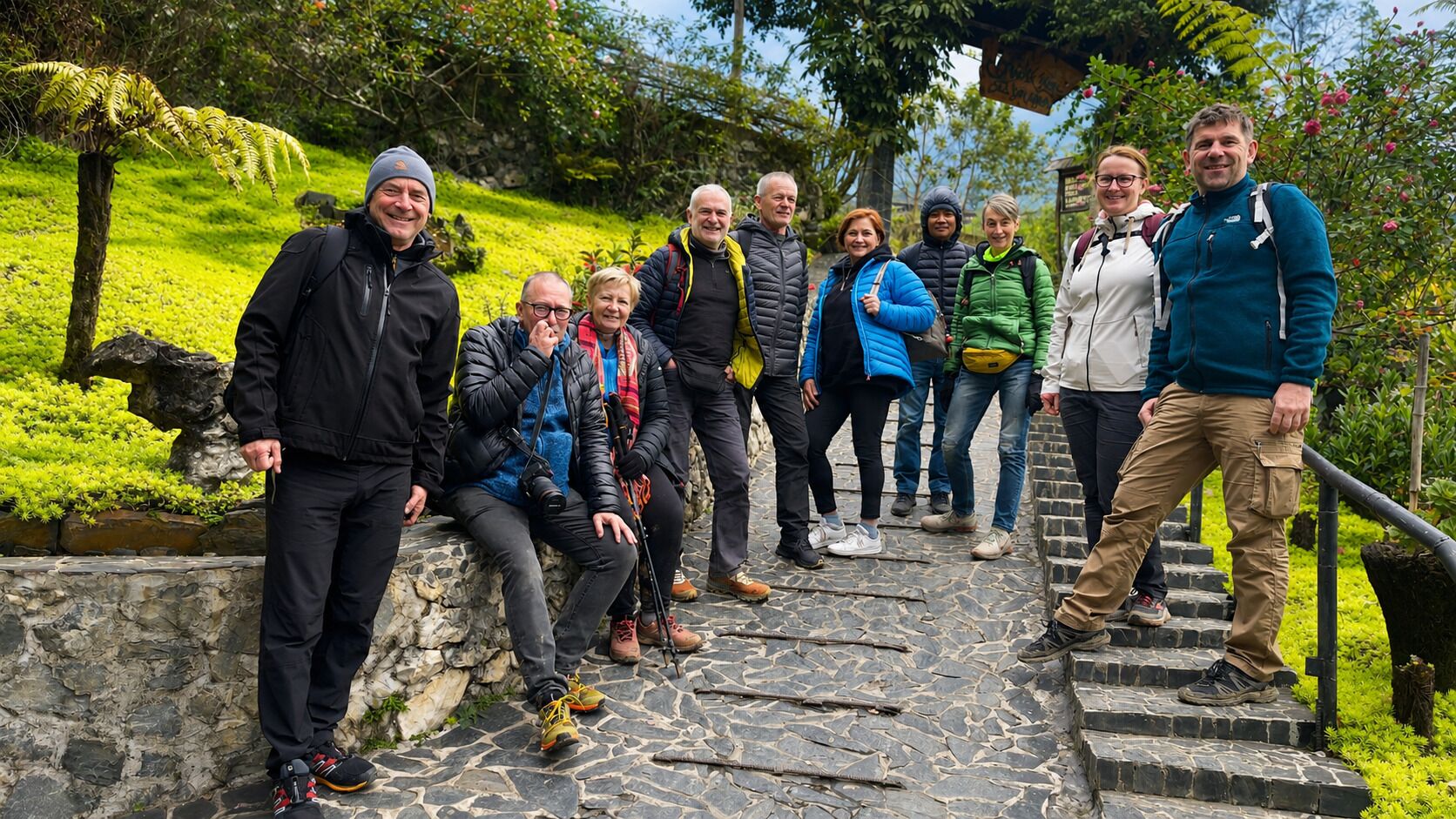 A group of people on a stone staircase surrounded by greenery.