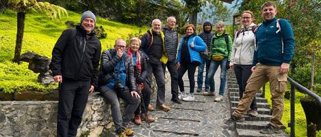 A group of people on a stone staircase surrounded by greenery.