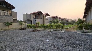 A residential complex with multiple two-story buildings, each featuring balconies and a gravel courtyard. - The premier gir resort (Talala)