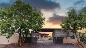 A gated entrance to The Premier Gir Resort with a clear view of the building and surrounding trees. - The premier gir resort (Talala)