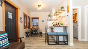 Une cuisine compacte dotée d’un îlot central, de planchers en bois et d’étagères intégrées.