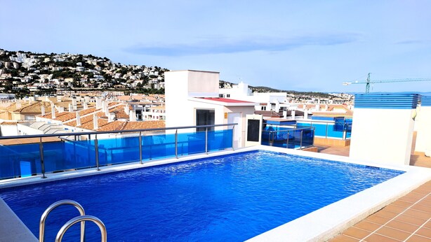 A rooftop swimming pool with clear blue water, surrounded by a white pool deck and metal railings. - Maestro Roca Playavacaciones (Peñiscola)