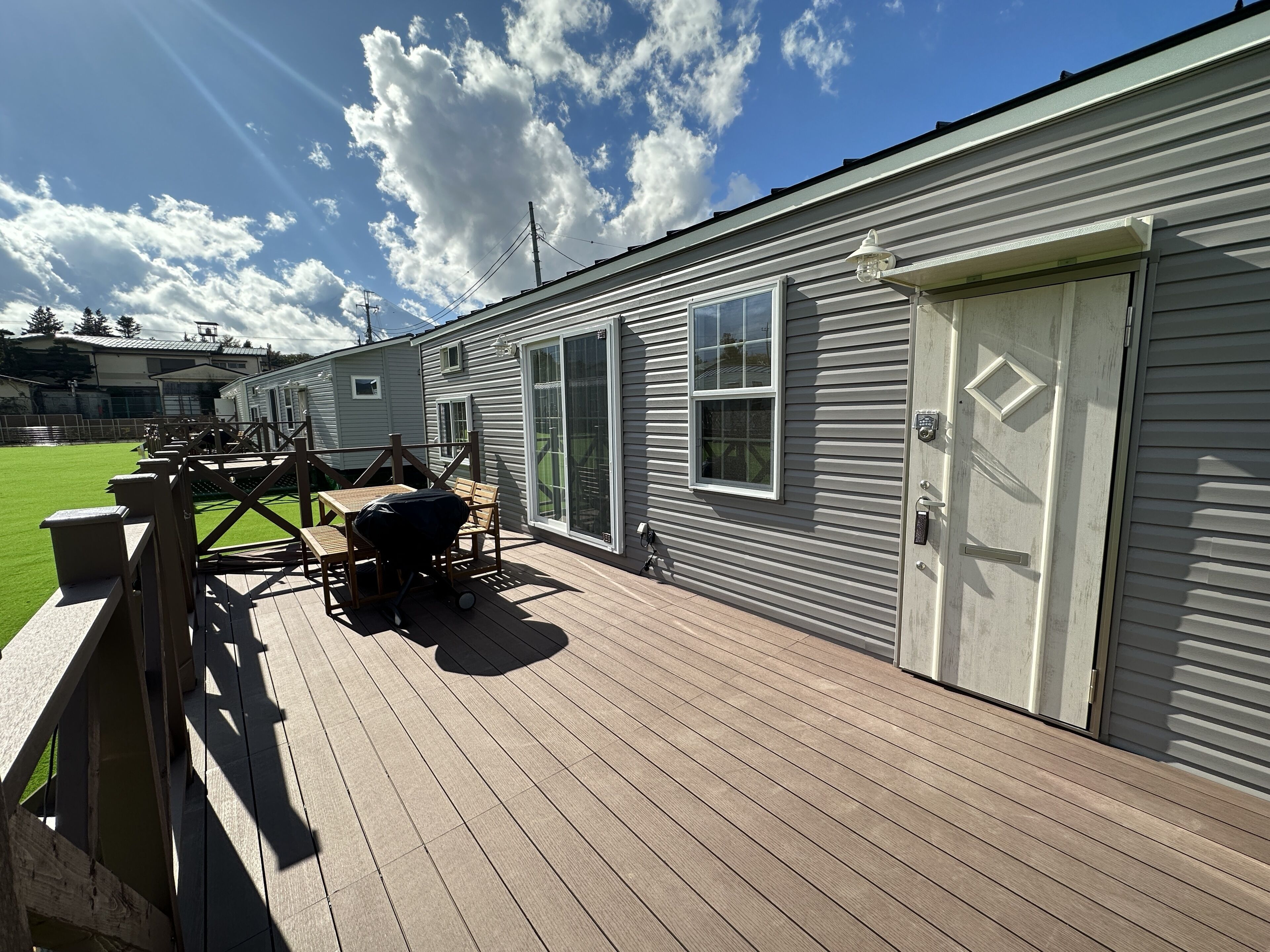 A single-story house with a deck, a sliding glass door, and a small window.