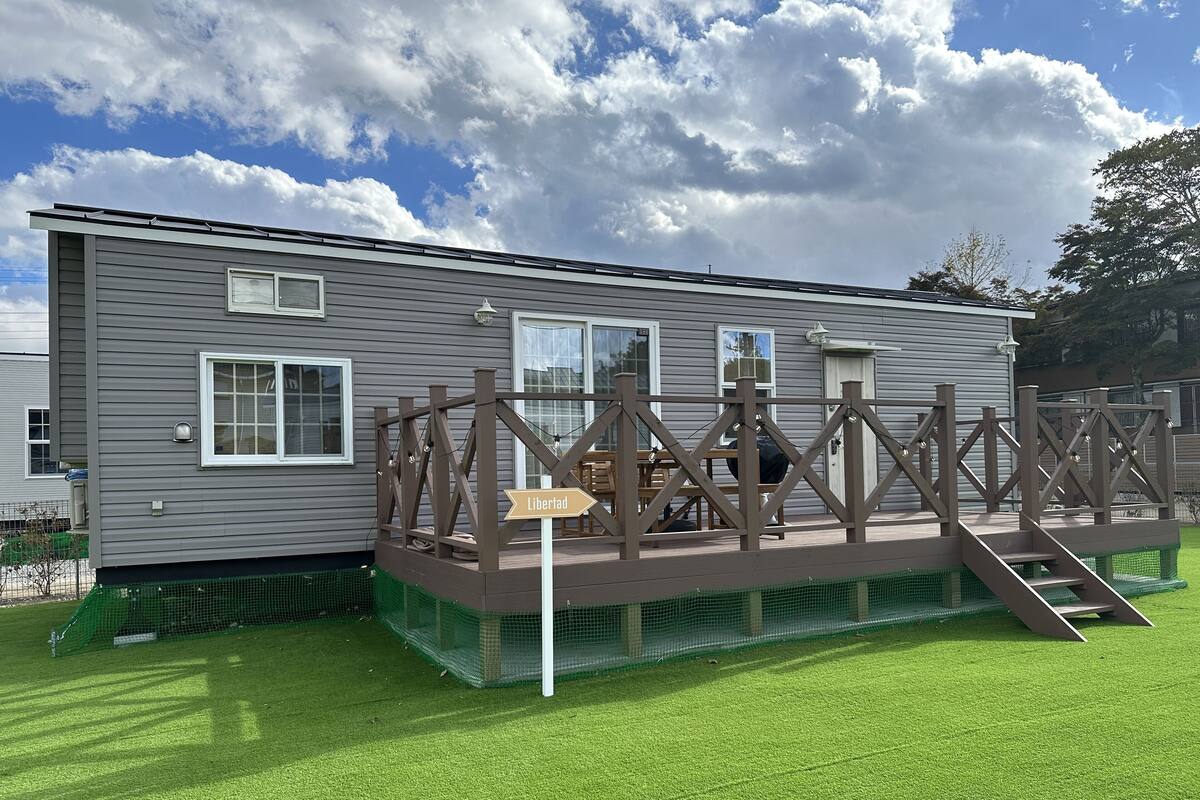Una casa móvil con una terraza y un letrero que dice 'Libertad'.