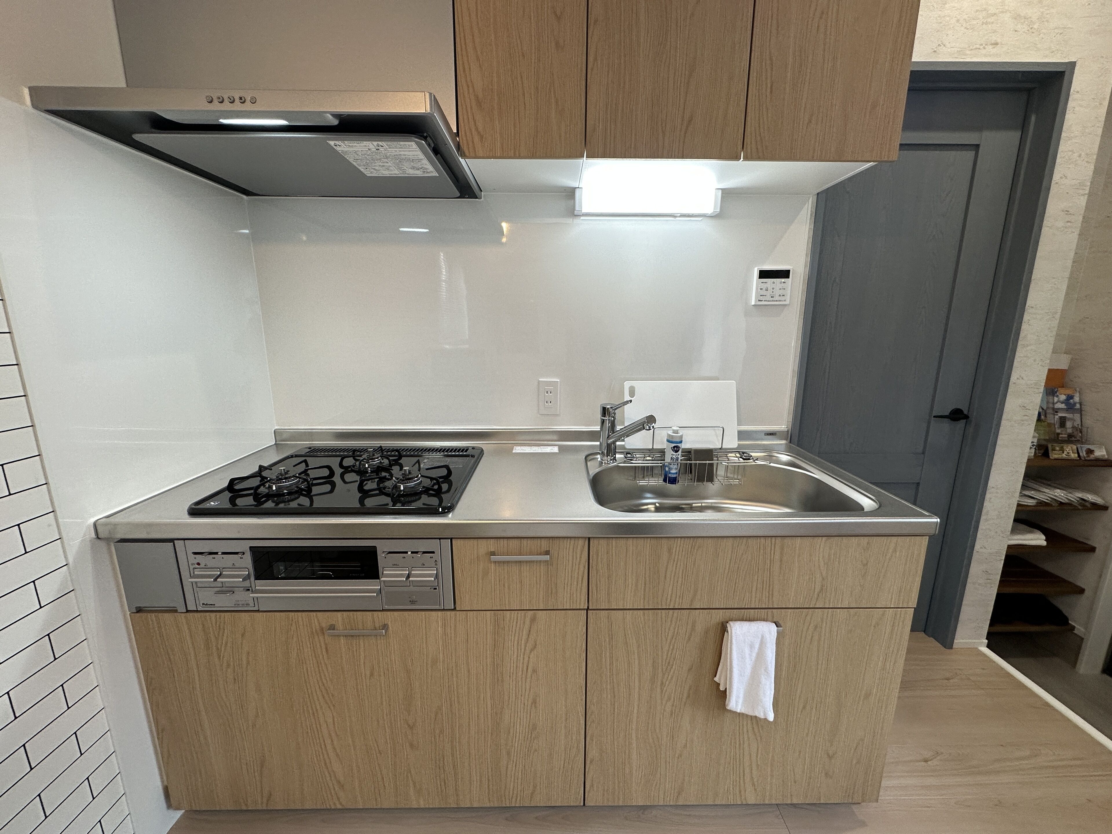 A modern kitchen with a stainless steel sink, a built-in dishwasher, and a gas stove.