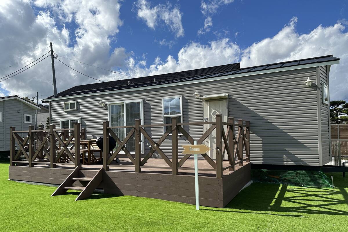 Un edificio residencial con terraza, un cartel que dice "Broom" y una parrilla de barbacoa en el exterior.