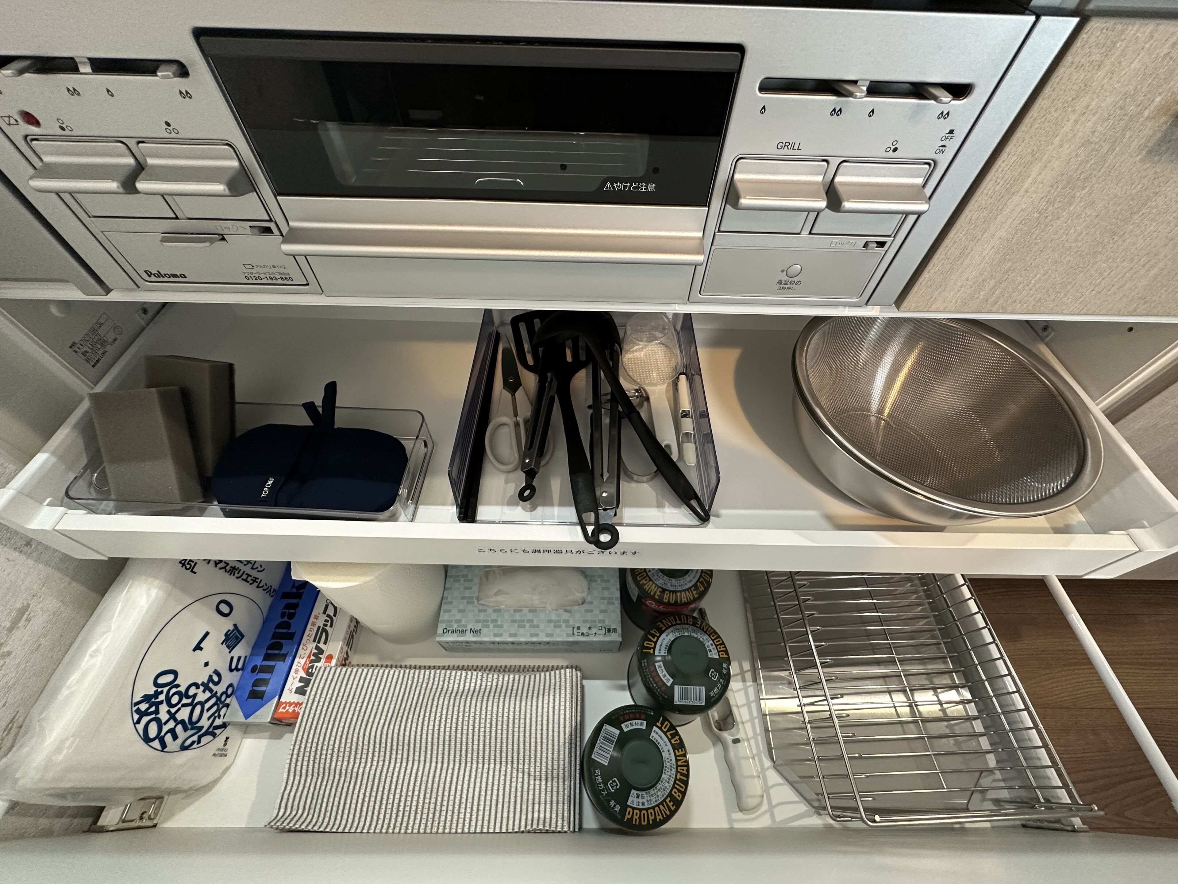 Cozinha equipada com micro-ondas, chapa, pia e diversos utensílios.