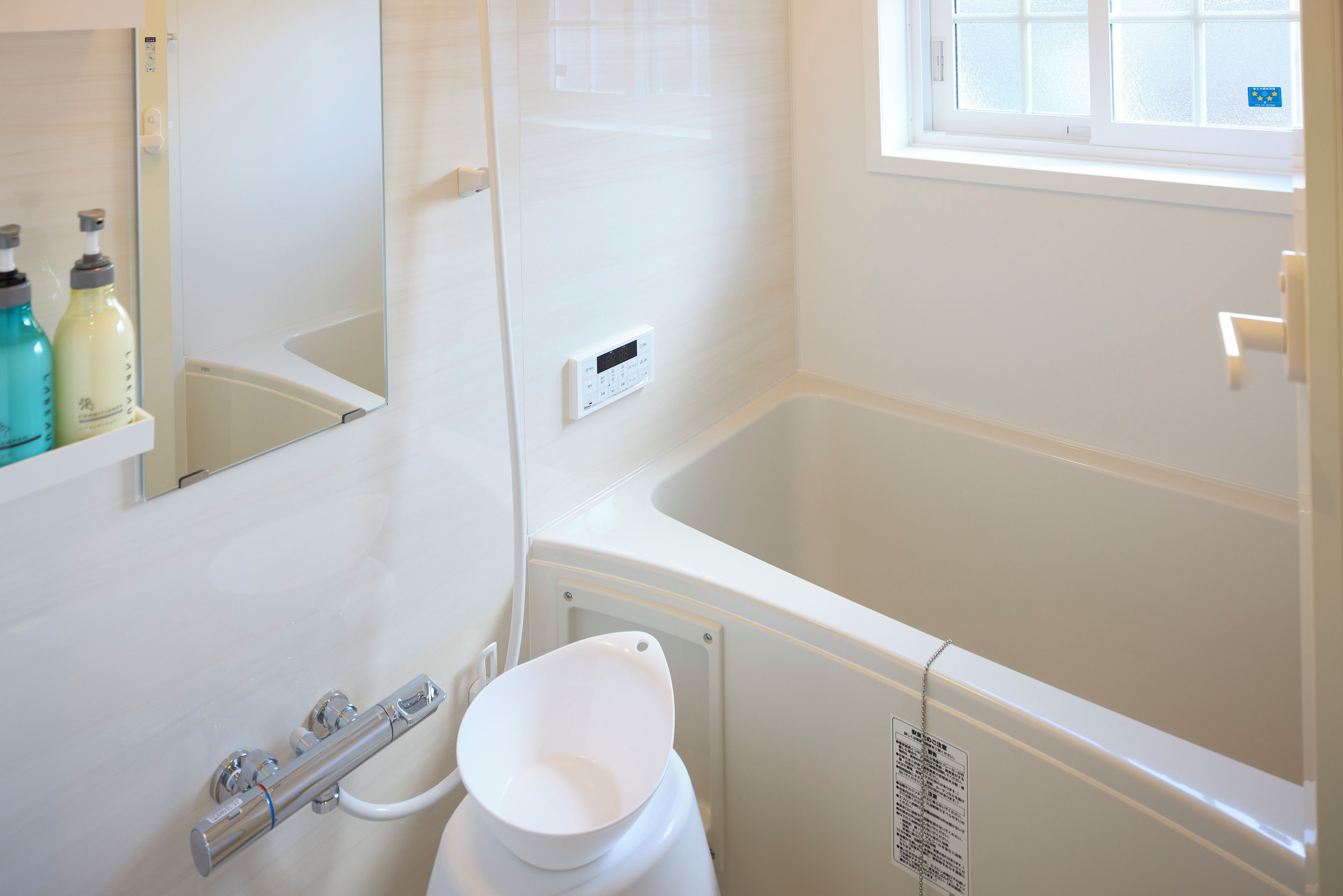 Een badkamer met een bad, toilet en douche.