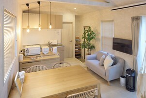 Una cocina moderna con comedor, sofá y televisor.