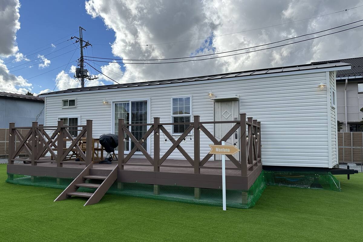 Una casa móvil blanca con una terraza marrón y un cartel que indica Montana.
